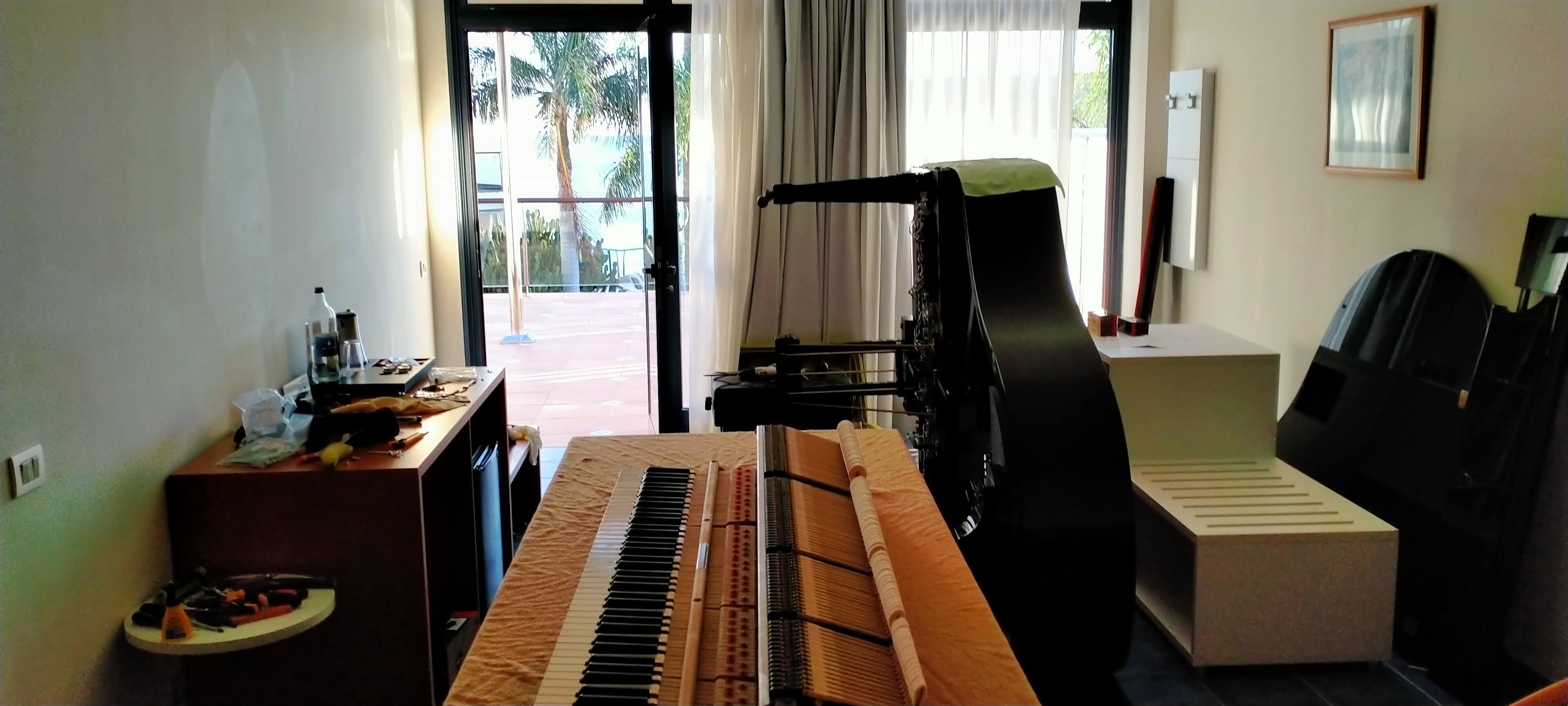 Piano de cola negro en habitación de cliente durante instalación