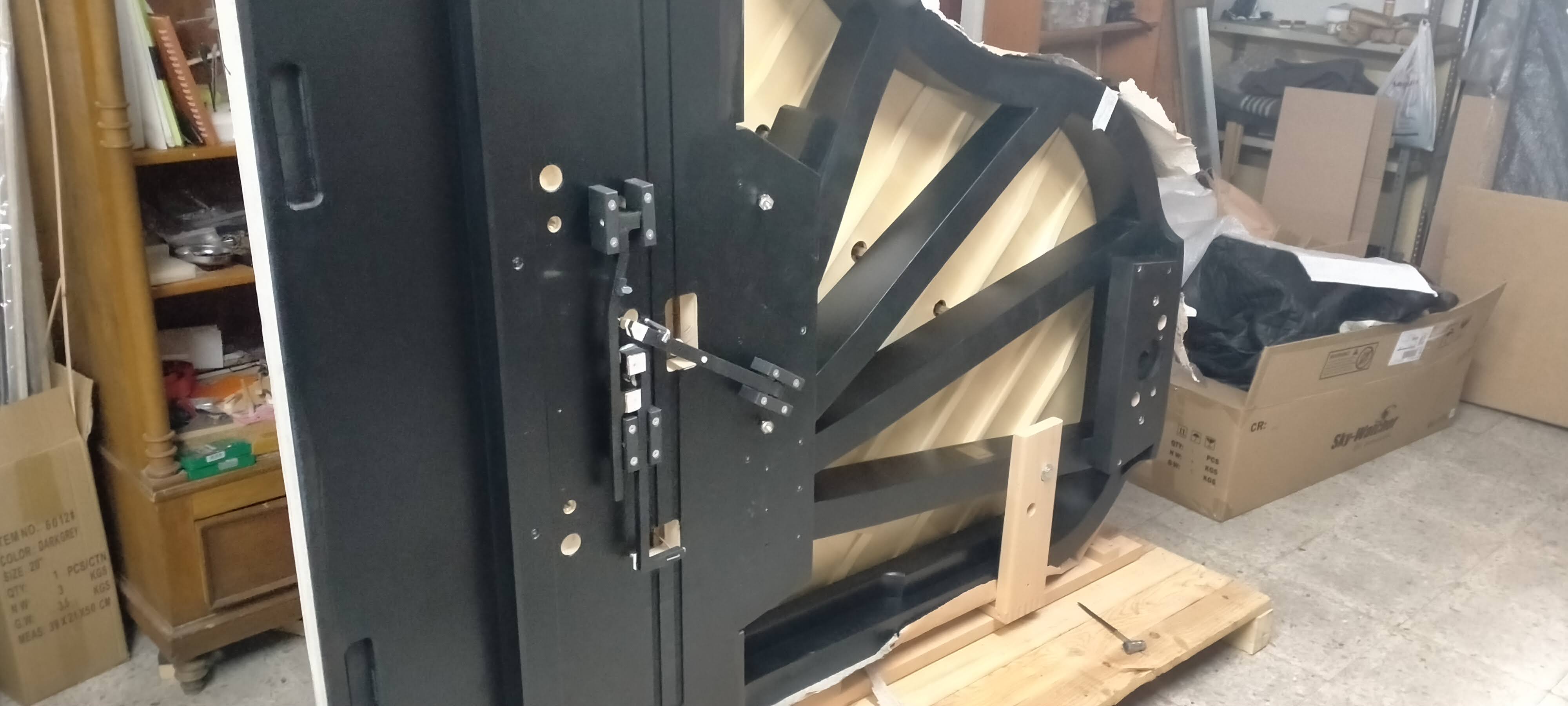 Piano de cola negro volteado en soporte de taller